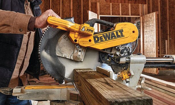 A large DeWalt saw cuts a pressure-treated post.