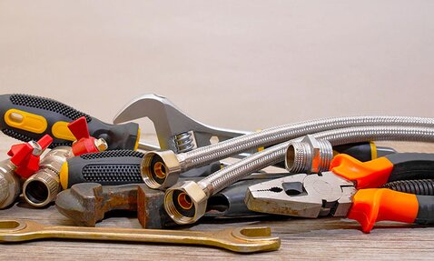 A group of plumbing tools and supplies lay in a pile.