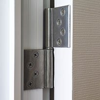 Two door hinges on a while interior door.