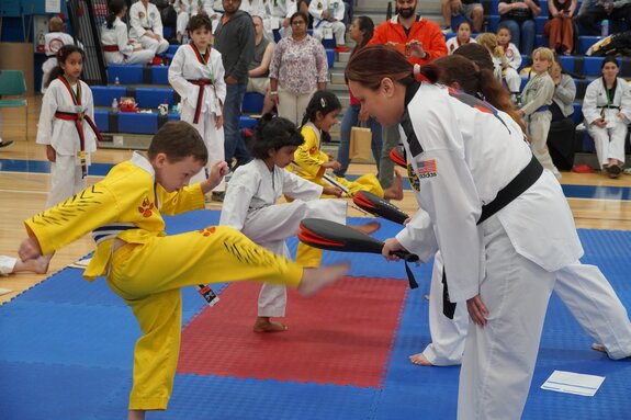 Pre-K aged students practicing their punches with an instructor
