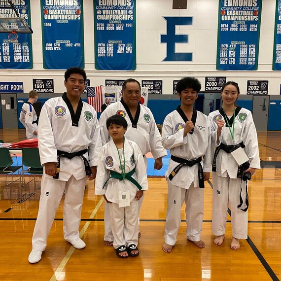 A group of martial art students showing their smiles and their broken boards after a belt test