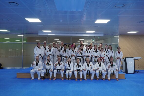 Black belt students performing a poomsae pattern together in sync
