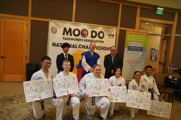 Group of new black belts celebrating their achievements at a promotion ceremony