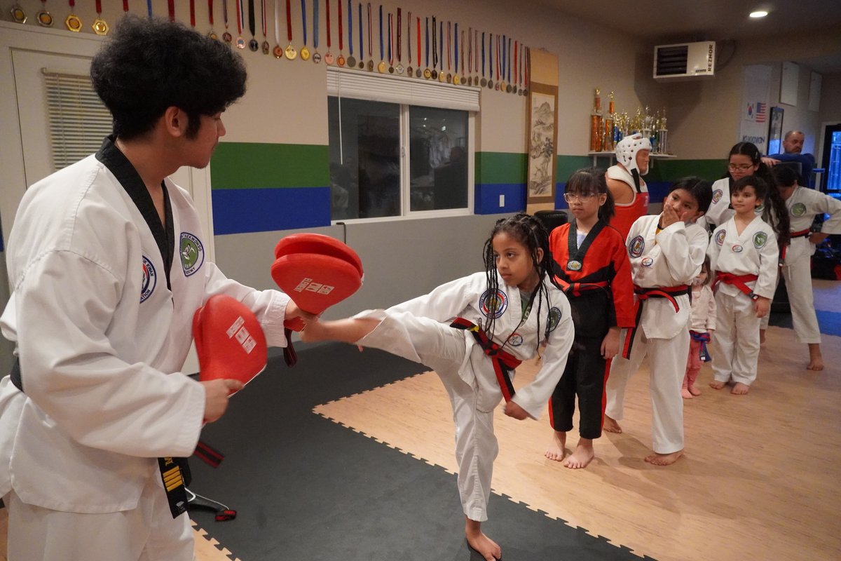 Students kicking targets in a line