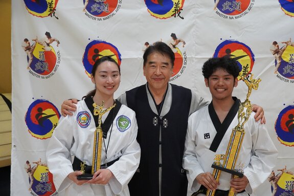Black belt students performing a poomsae pattern together in sync