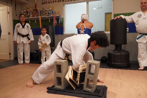 A student is breaking a board at a tournament