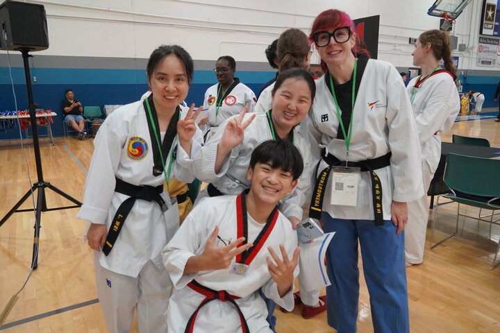 A group of cheerful kids and adults in martial arts uniforms