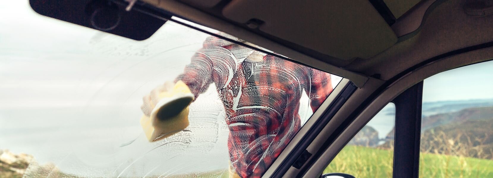 Driver cleaning windscreen