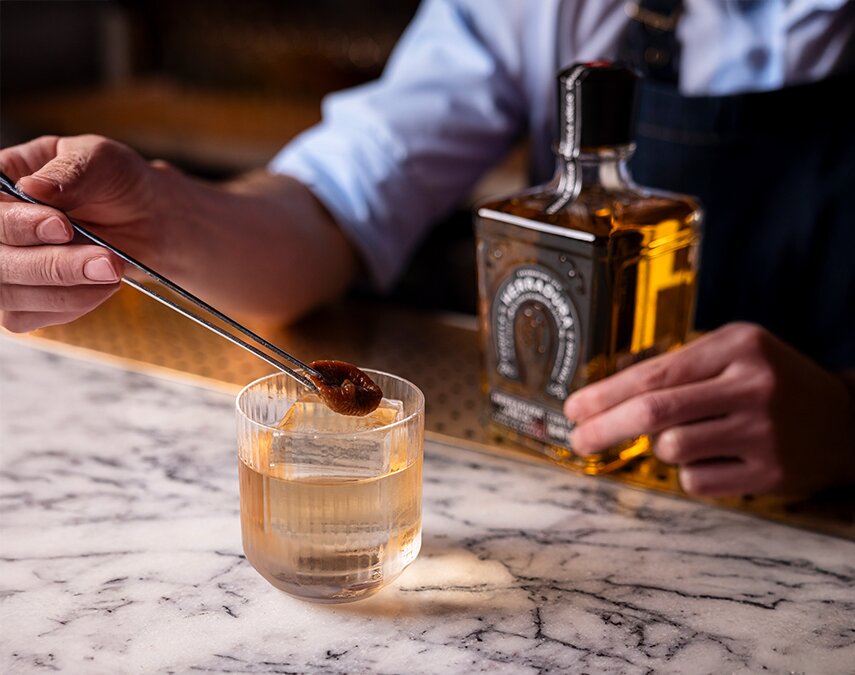 A bottle of Herradura Añejo Tequila and cocktail