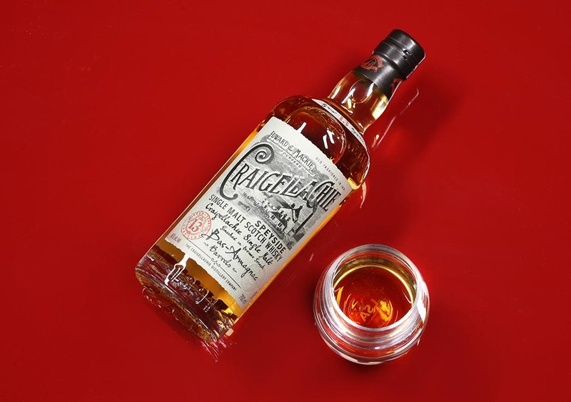 A bottle of Craigellachie Speyside Single Malt Whisky on a red background.