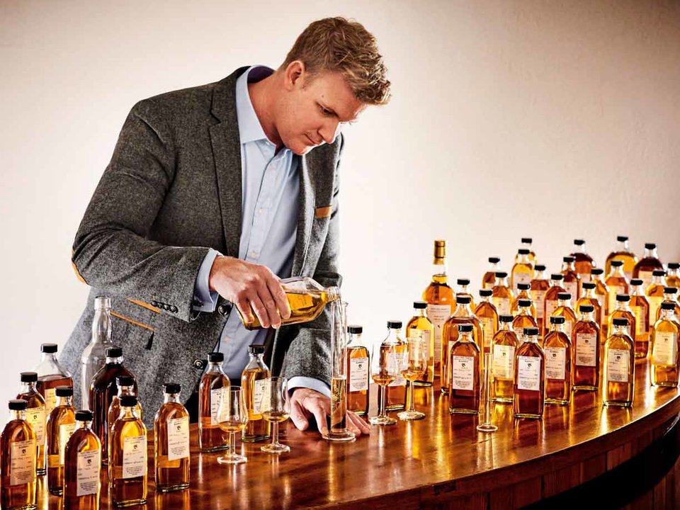 Dr. Nick Savage surrounded by whisky sample bottles