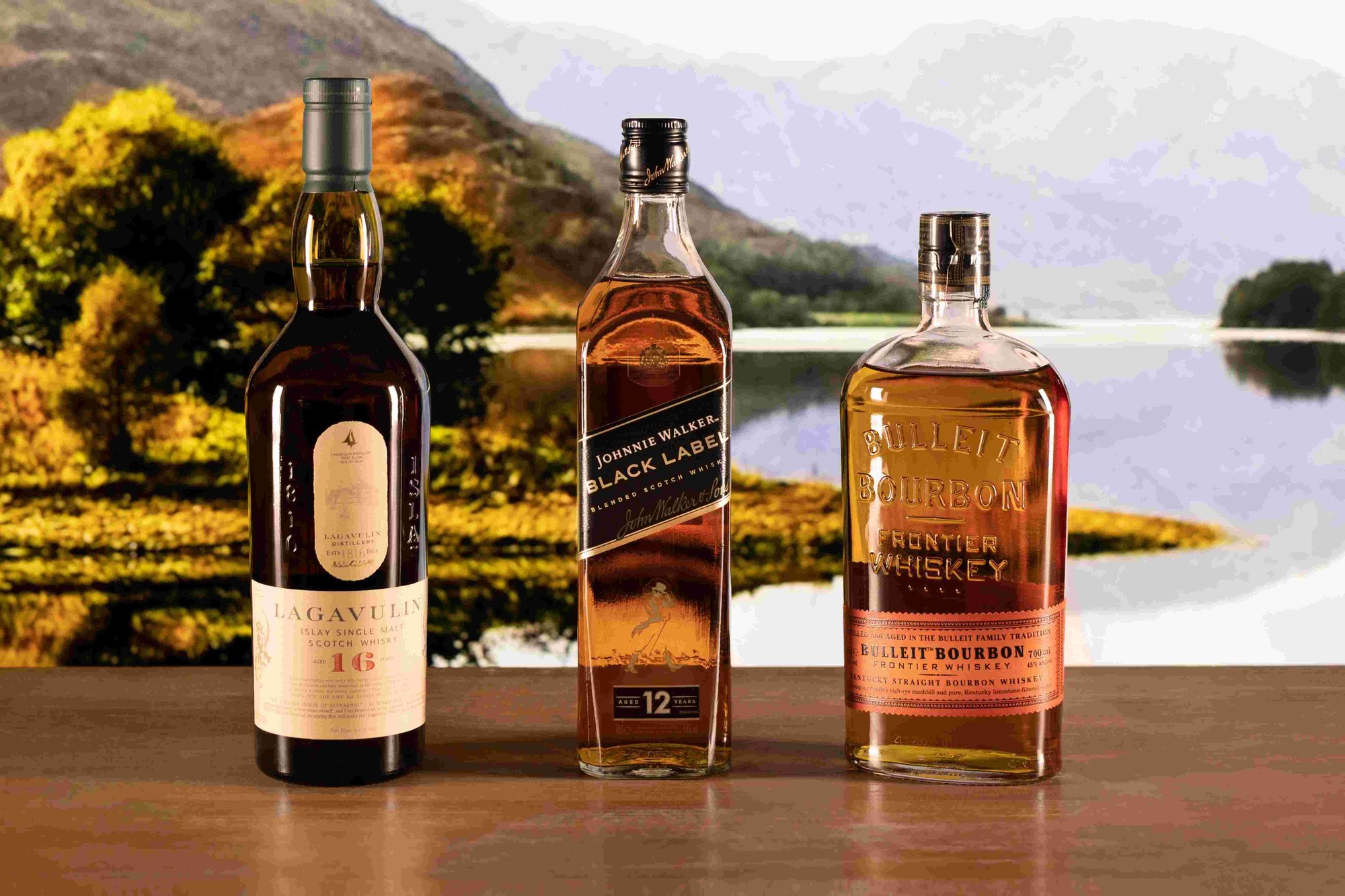 Three bottles of whisky on a coastal background