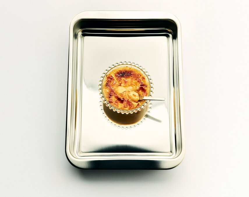 A metal tray with a Creme Brulee in it