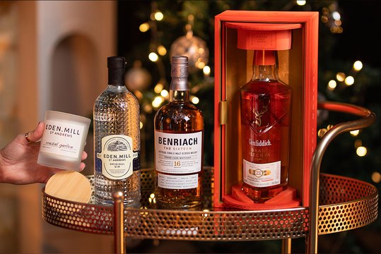 A old-fashioned whisky gift, gin gift with candle and glasses on a Christmas setting