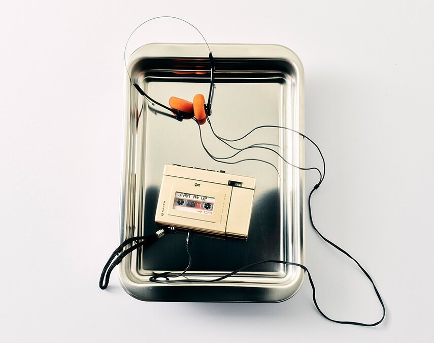 A metal tray with a retro walkman in it
