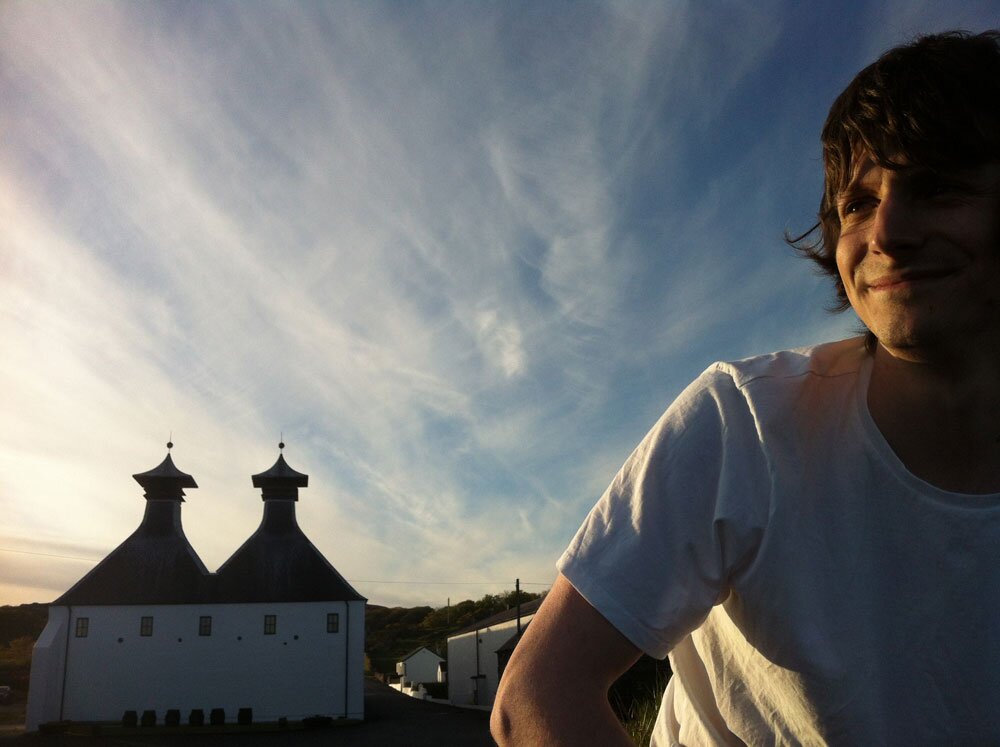 Jake at Ardbeg distillery beneath blue sky