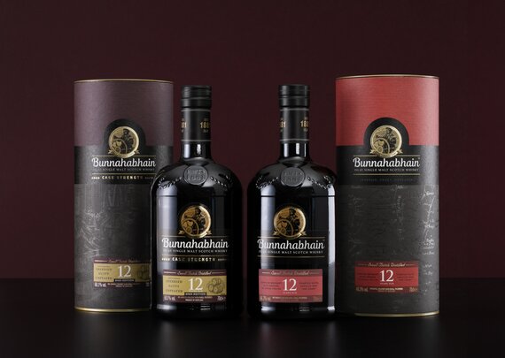 A bottle of Bunnahabhain 12 year old and Bunnahabhain 12 year old cask strength on a purple background.