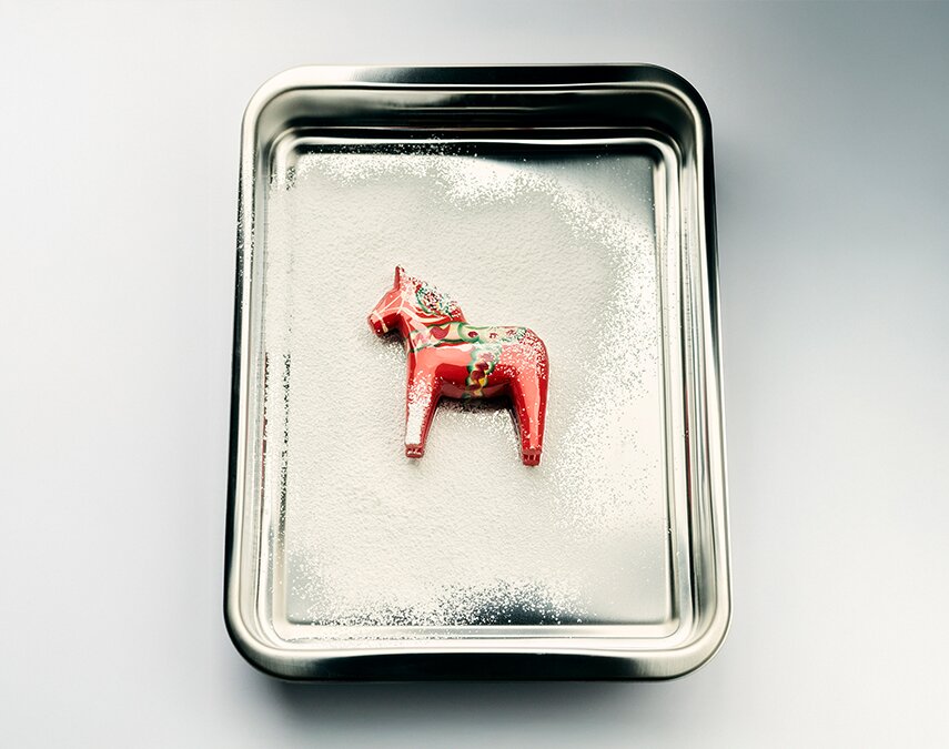 A metal tray with a Swedish horse decoration in it