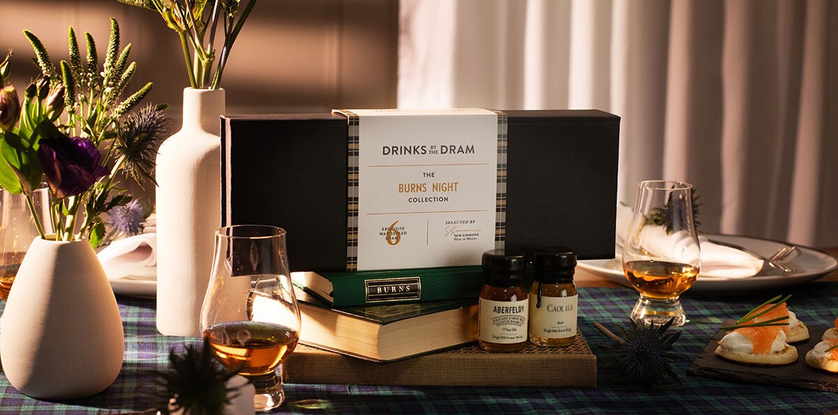 A Drinks by the Dram Burns Night tasting set on a tartan tablecloth dinner setting.