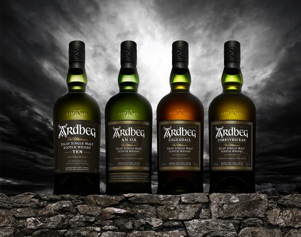 Four bottles of Ardbeg on a stone wall. 