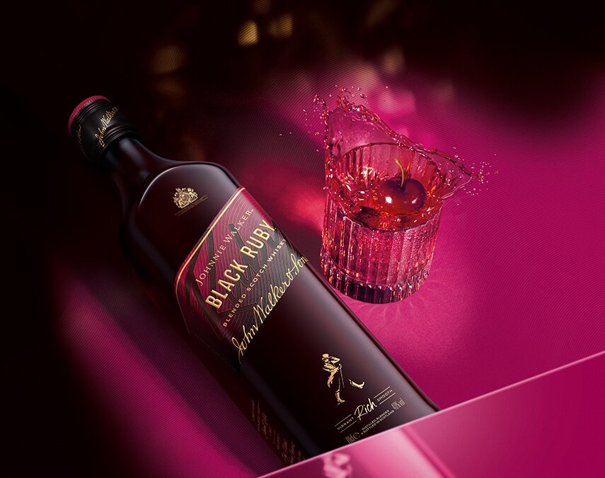 Image of a bottle of Johnnie Walker Black Ruby whisky held by a man.