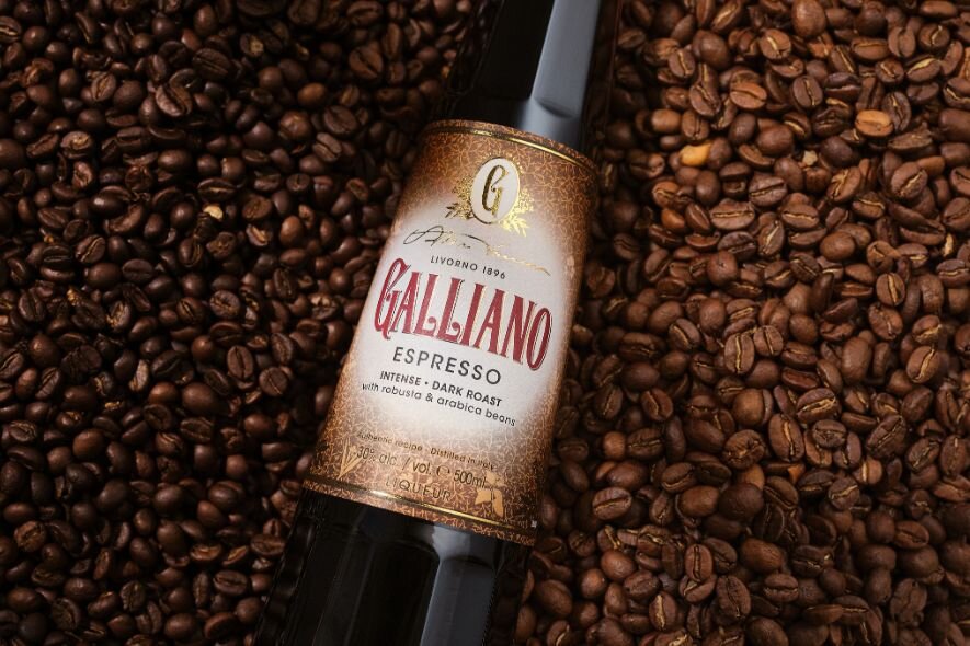 A bottle of Galliano Espresso on a pile of coffee beans. 