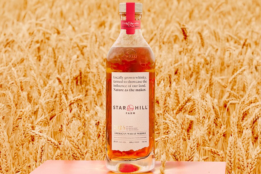 A bottle of Star Hill Farm in a field.