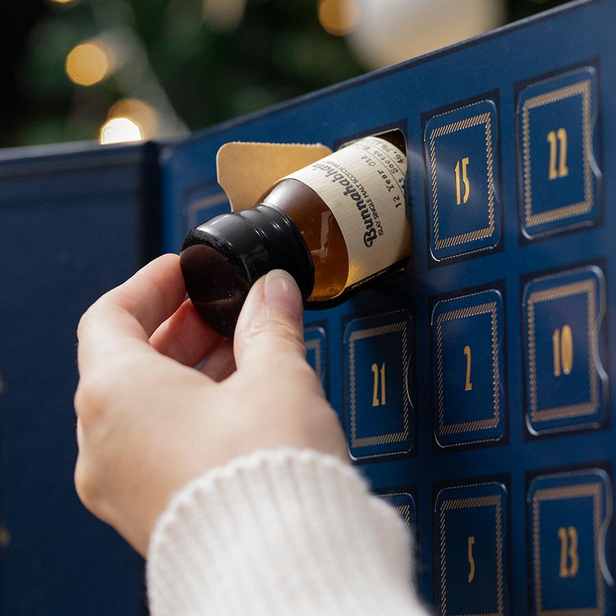 A dram of whisky being removed from a Scotch advent calendar