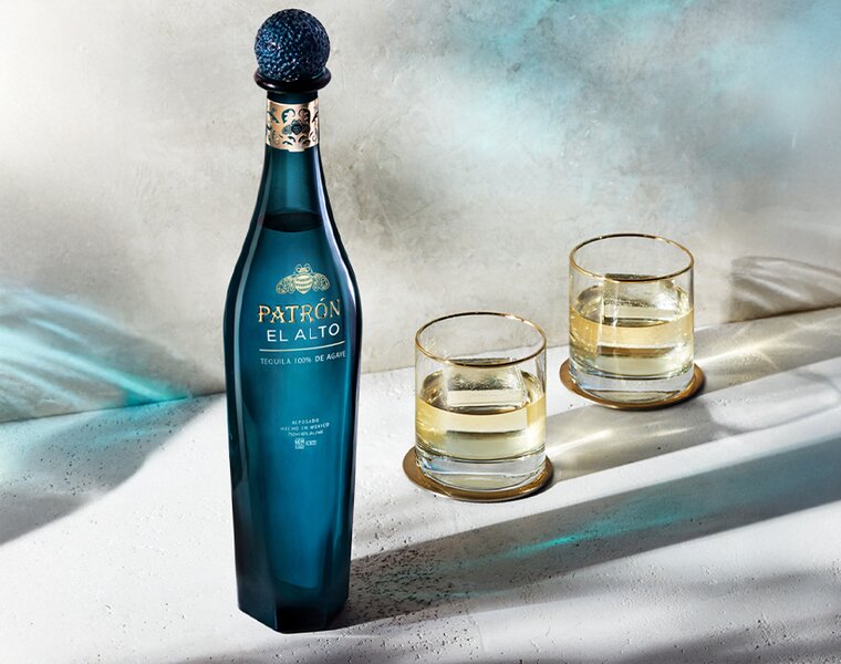 A bottle of Patrón El Alto Tequila with two glasses.