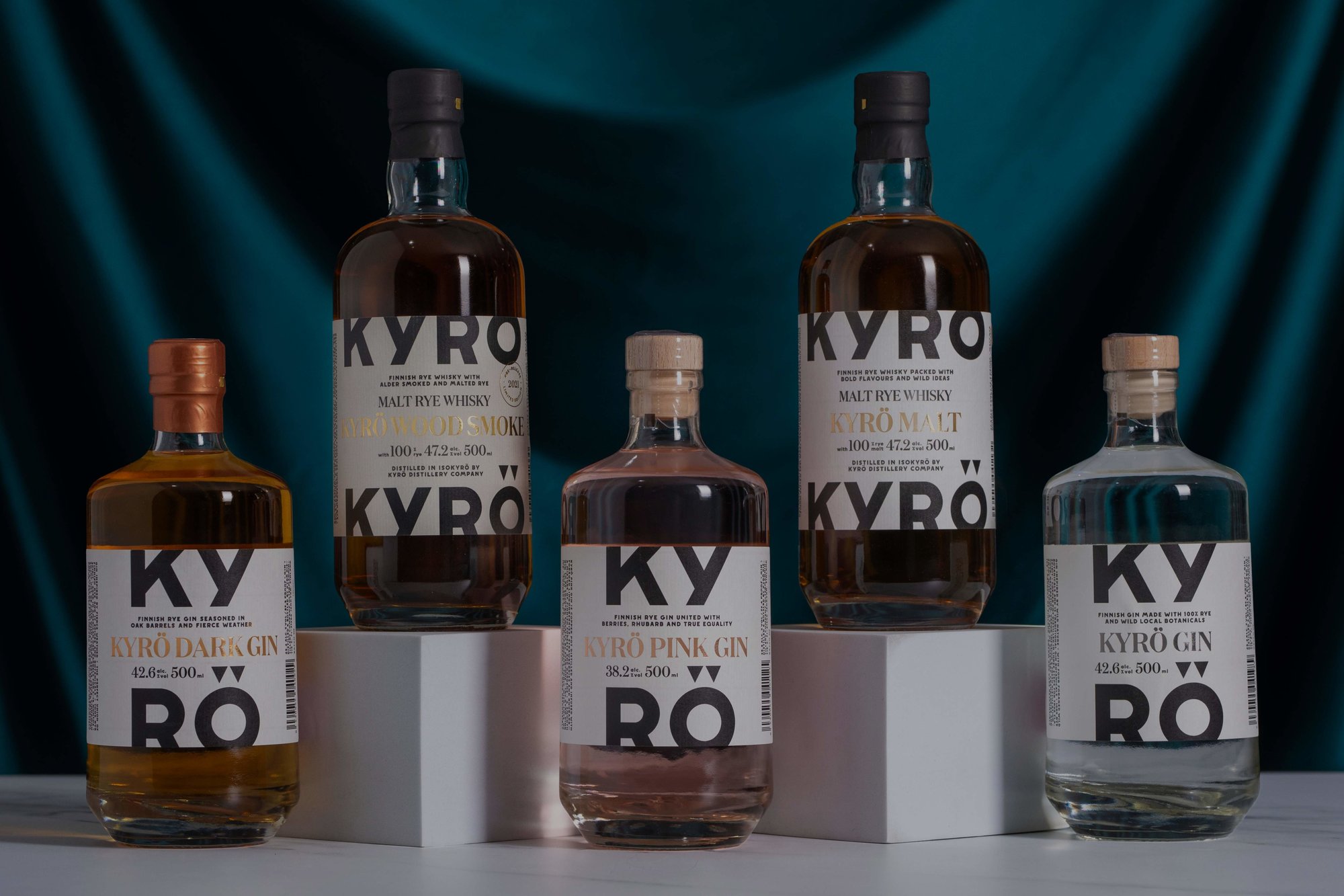 Five bottles of Kyro spirits on a white surface