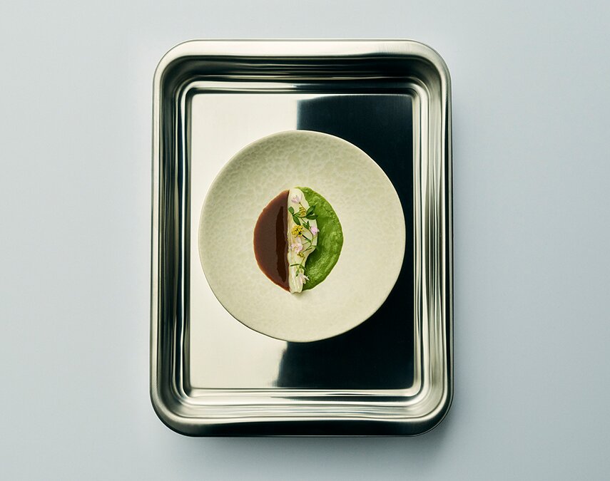 A metal tray with a gourmet meal in it