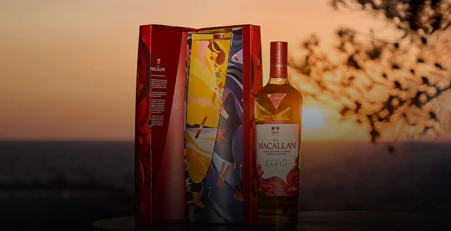 A bottle of the Macallan A Night On Earth First Light with its presentation box at sunrise.