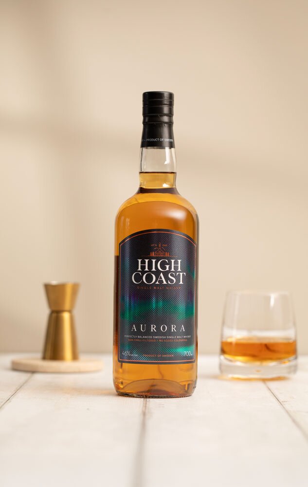 High Coast Aurora whisky bottle in front of tumbler glass and jigger