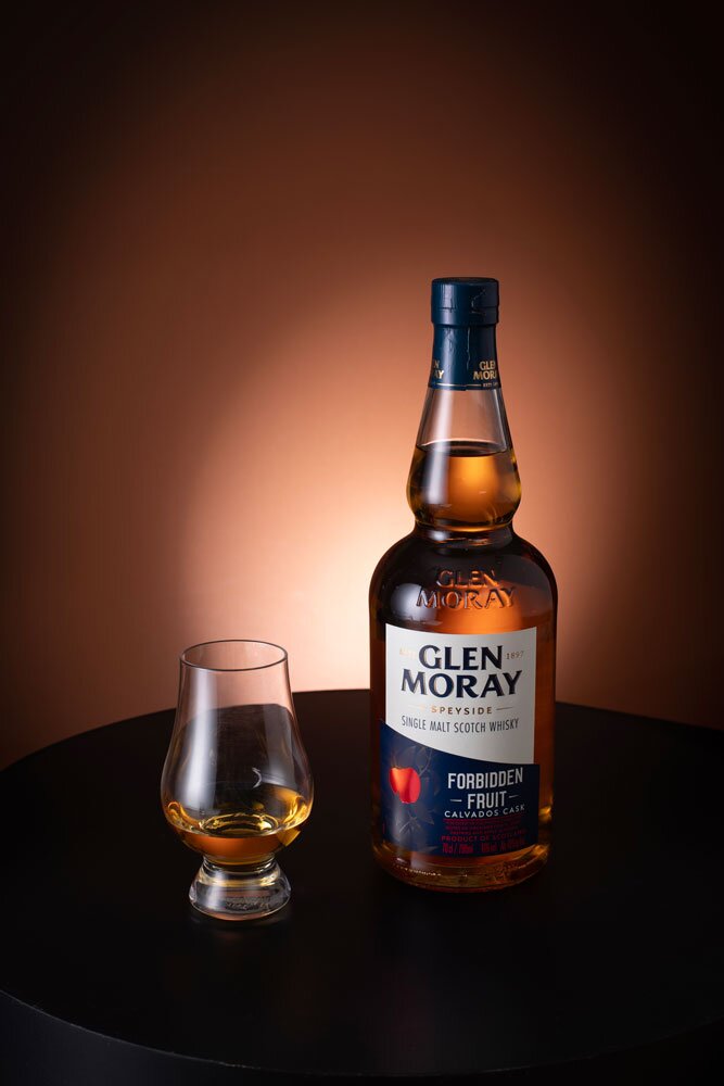 Glen Moray Forbidden Fruit whisky bottle with Glencairn glass