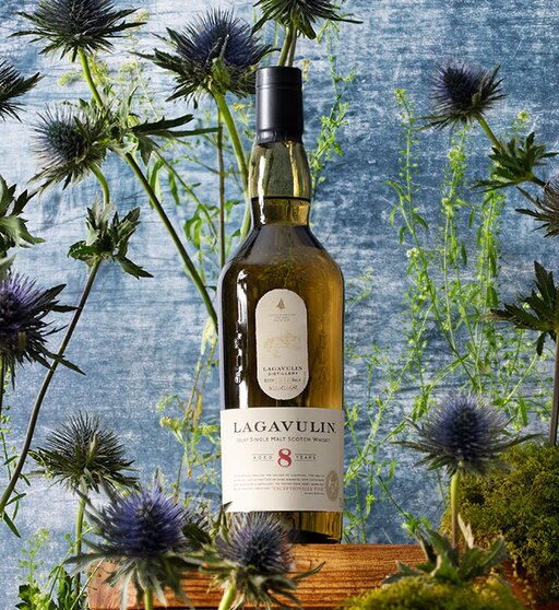 A bottle of Lagavulin 8 Year Old surrounded by thistles. 