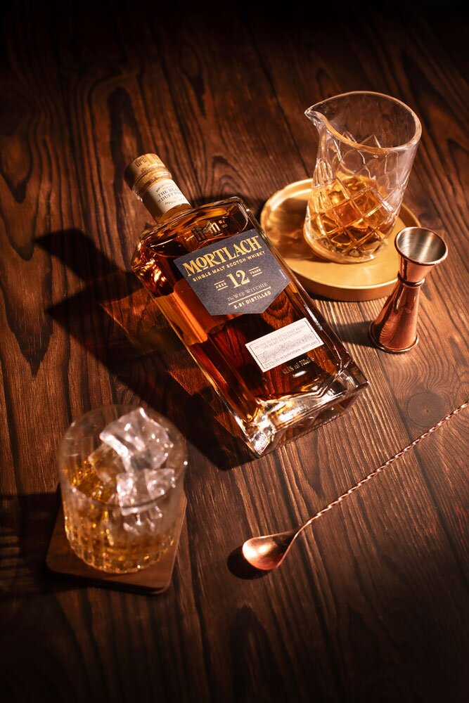 Mortlach 12 Year Old whisky bottle with glass and barware