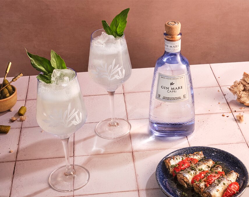 A bottle of Gin Mare Capri next to G&Ts.