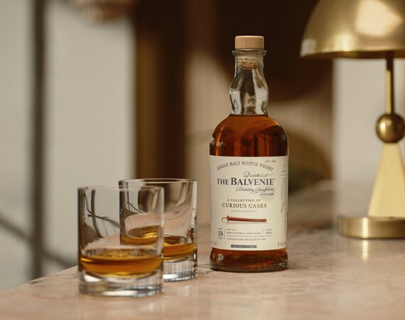 A bottle of The Balvenie Stories 18 year old French Pineau cask and 2 glasses of whisky.