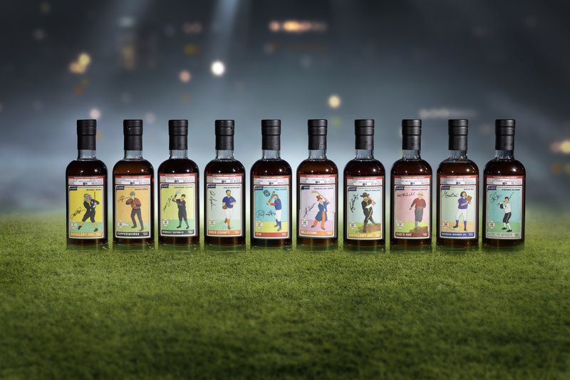 That boutique-y whisky company line up of bottles on a grass field.