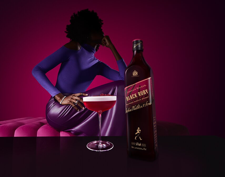 Image of a bottle of Johnnie Walker Black Ruby whisky next to a cocktail.