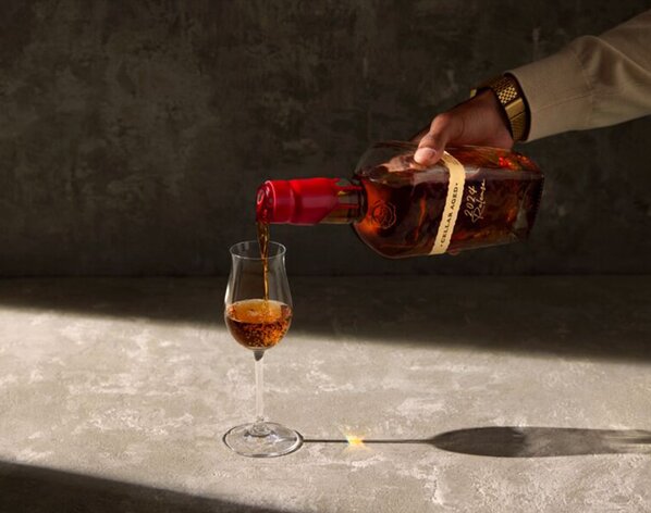 A bottle of Maker's Mark Cellar Aged 2024 Release being poured into a glass