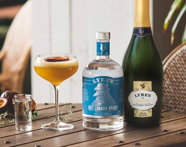 A Lyre's Passionstar Martini cocktail with a bottle of Lyre's Dry London Spirit and Lyre's Sparkling Classico.
