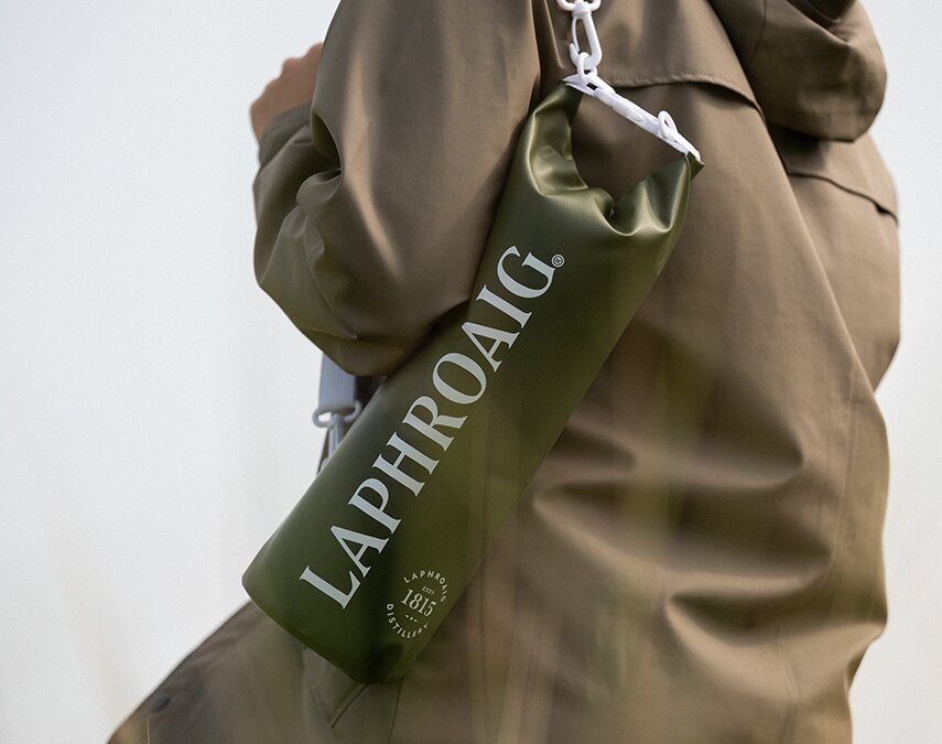Laphroaig branded dry bag Gift with purchase being  worn by a person.