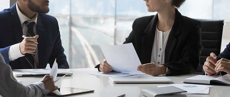 People in suits sitting at an office table