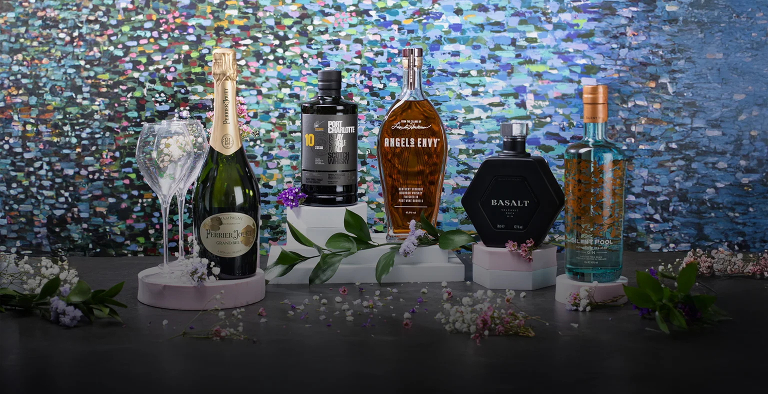 Five bottles of spirit against a floral background.