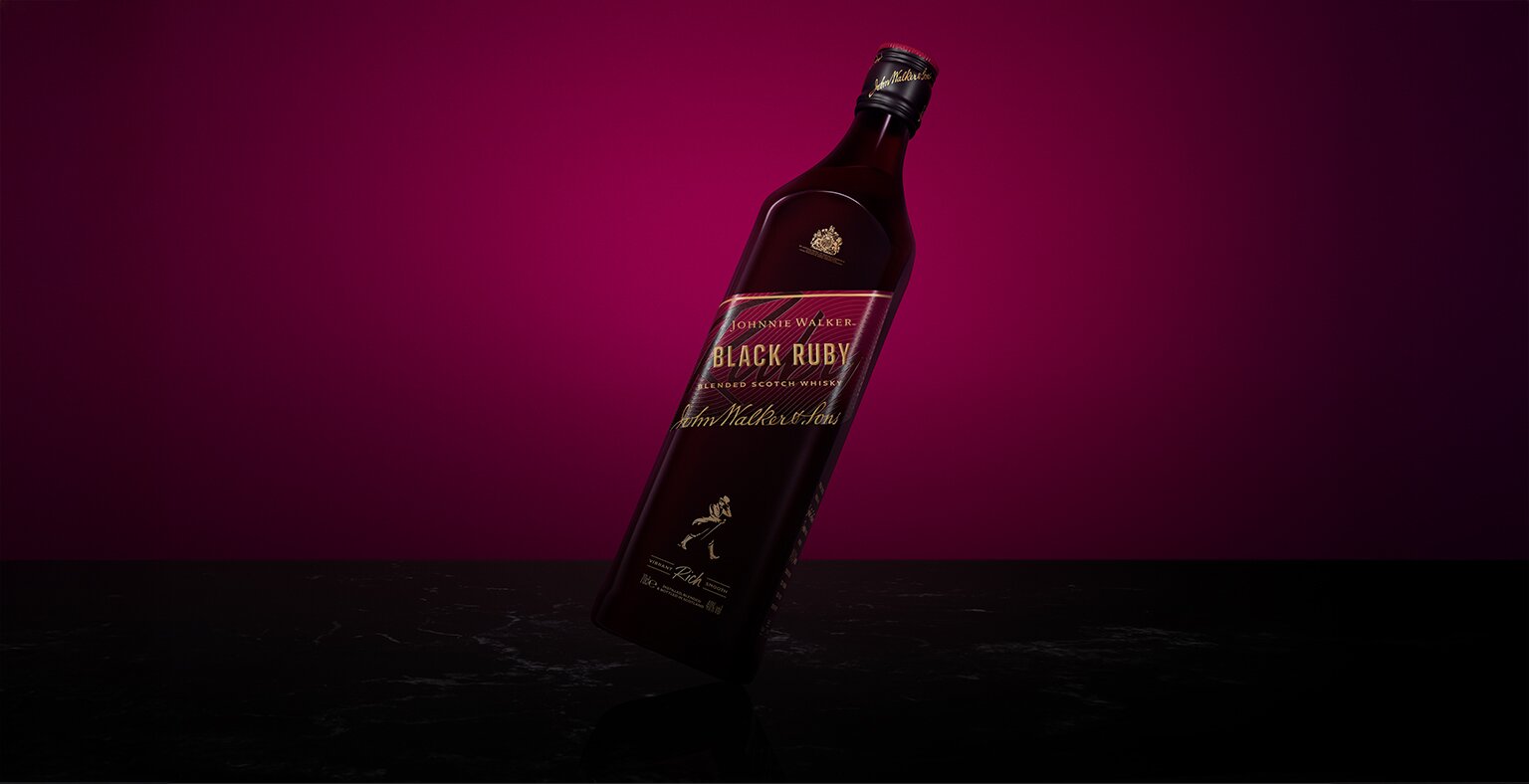 A bottle of Johnnie Walker Black Ruby against a ruby background.