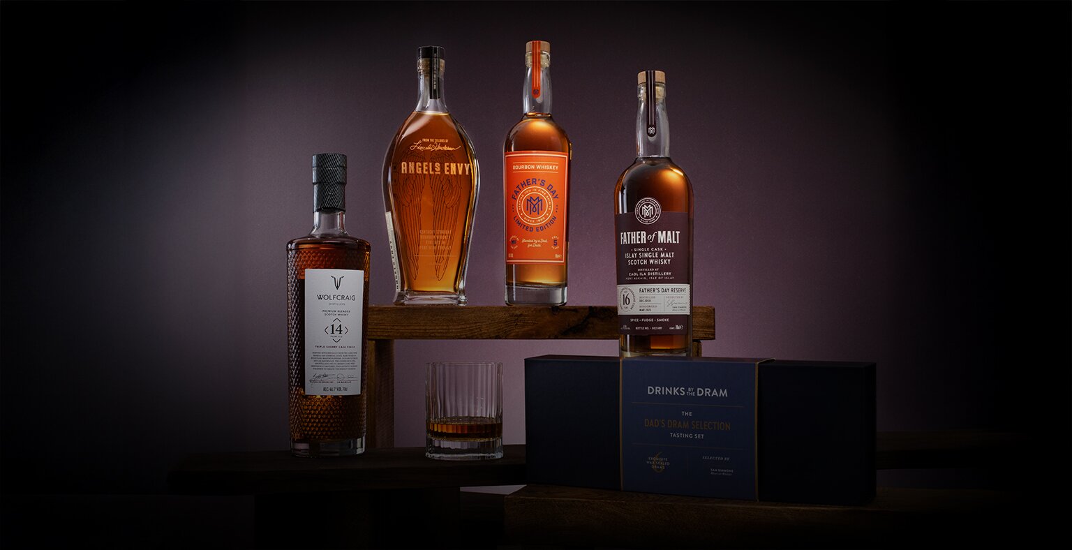 Four bottles of whisky and a tasting set on a purple background.