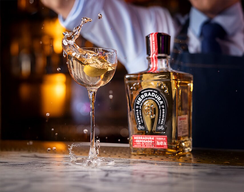 A bottle of Herradura Reposado Tequila and cocktail
