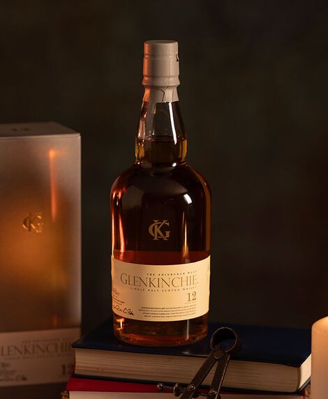 A bottle of Glenkinchie 12 year old whisky against a dark background and it's presentation box. 