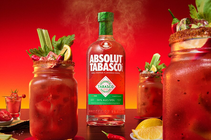 Absolut Tabasco and some bloody marys cocktails against a red background.